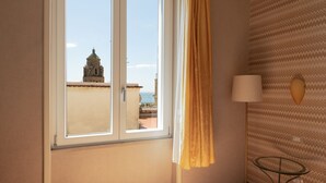 A room with a large window, a lamp, and a patterned wall.
