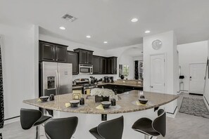 Enjoy cooking in this well-equipped kitchen with a central island, sink, and ample counter space.