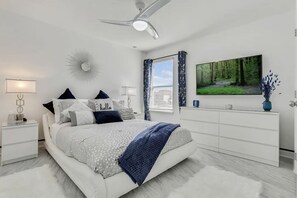 Cozy retreat with a central bed, nightstand, dresser, and flat-screen TV.