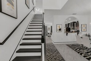 Staircase leads to an upper level with a kitchen area and additional room.
