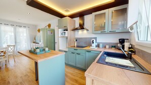 Una cocina moderna con armarios azul claro, encimera de madera y estufa empotrada.