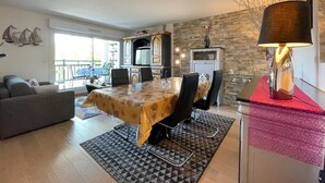 Una sala de estar moderna con comedor, chimenea y balcón con vistas.