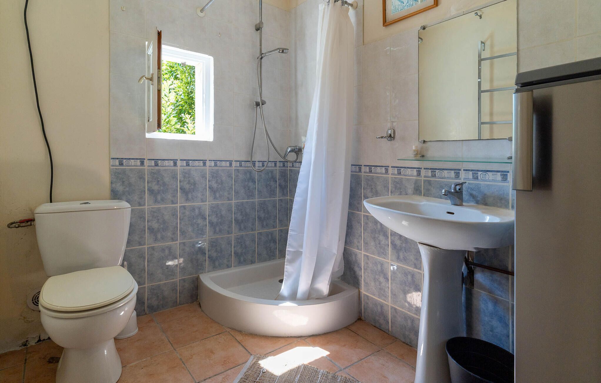 Et badeværelse med toilet, badekar og vask.