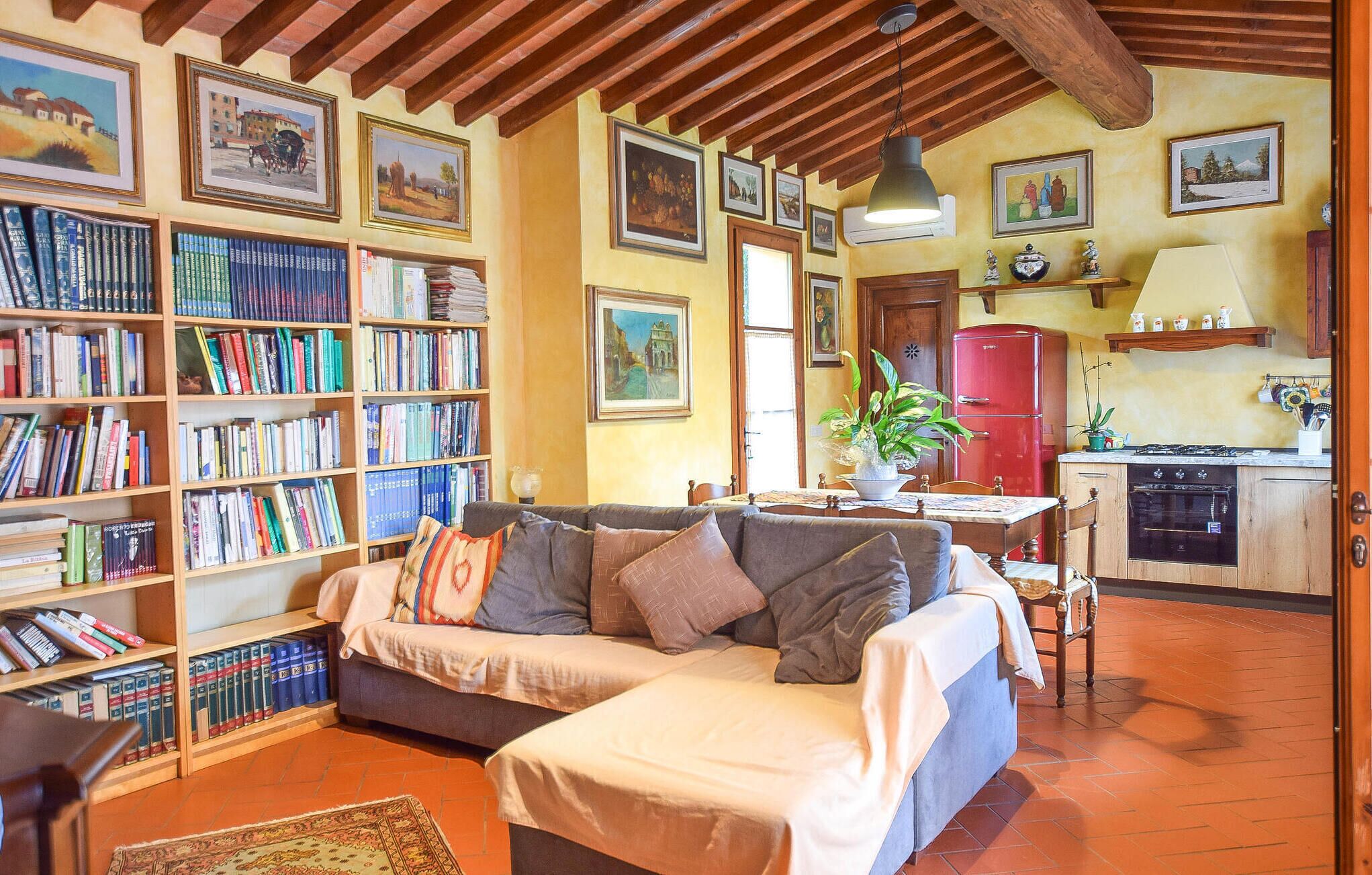 Una sala de estar acogedora con un sofá, una estantería y un comedor con mesa y sillas.