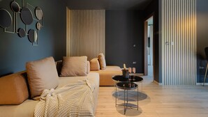 Uma sala de estar moderna com um sofá, uma mesa de centro e um objeto decorativo na parede.
