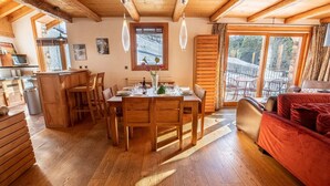 Ein gemütliches Holzinterieur mit Essbereich, Küche und einer Couch.