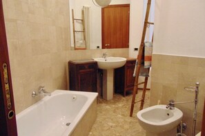 Un bagno con una vasca, un lavandino e un bidet.