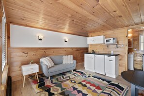 Cozy living space with a sofa, side table, and kitchen area.