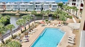 Ein Hotel mit Pool, Palmen und Blick auf das Wasser.