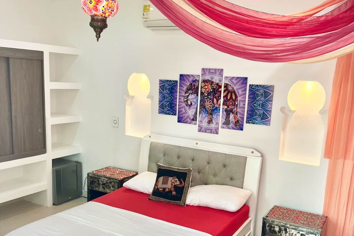 A modern bedroom with a bed, decorative wall art, and ambient lighting.