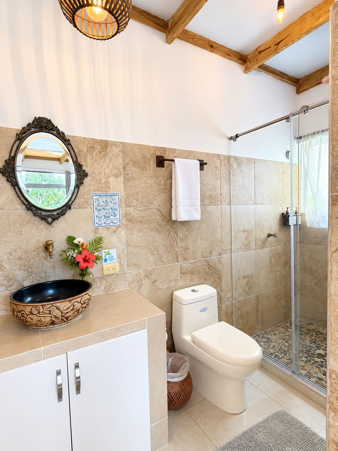 A bathroom with a shower, toilet, sink, and a mirror.
