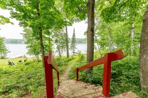 A wooden staircase leading to a lake surrounded by trees. - Lone Pine: Fall Stanley Lake Getaway | Fishing | Ski Brule | Sleeps 4 (Iron River)
