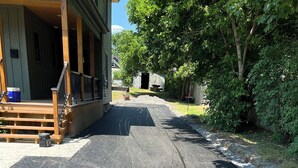 A residential driveway with a wooden staircase leading to a porch.