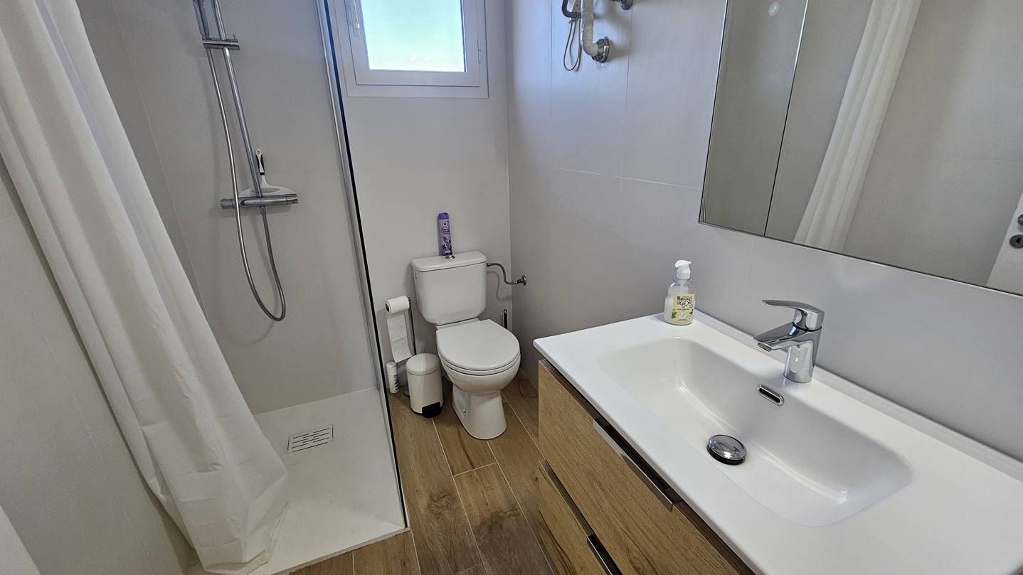 Ein Badezimmer mit Dusche, Toilette und Waschbecken.