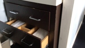 A bathroom with a white sink, a dark wooden vanity, and a drawer with a white towel. - Hitching Post Country Motel (Cornwall Bridge)