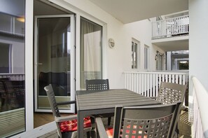 A balcony with a table and chairs, a sliding glass door, and a white railing. - Die Ferienwohnung Nr. 06 in der Villa Karola - Villa Karola (Göhren)