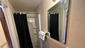 A bathroom with a sink, mirror, and shower curtain.