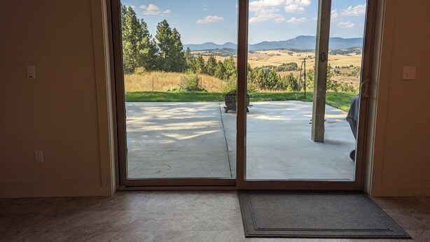 A room with a large sliding glass door leading to a concrete patio with a metal fire pit. - Hawk's Nest
Entire 1650 Sqft lower level.  (Moscow)