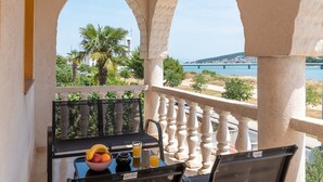 Un balcon avec une table dressée pour le petit-déjeuner, offrant une vue panoramique sur un pont et des palmiers.