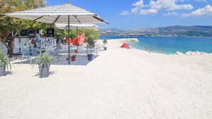 Un café situé en bord de mer, avec une terrasse et vue sur l’océan.