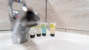 Ein Waschtisch mit vier Pflegeprodukten: nährendem Conditioner, revitalisierendem Shampoo, erfrischendem Duschgel und feuchtigkeitsspendender Körperlotion.