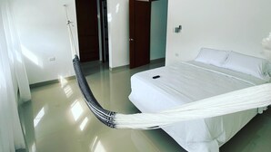 Een moderne slaapkamer met een bed, een plafondventilator en een hangmat.
