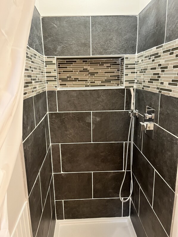 Een douche, handdoeken, zeep, shampoo