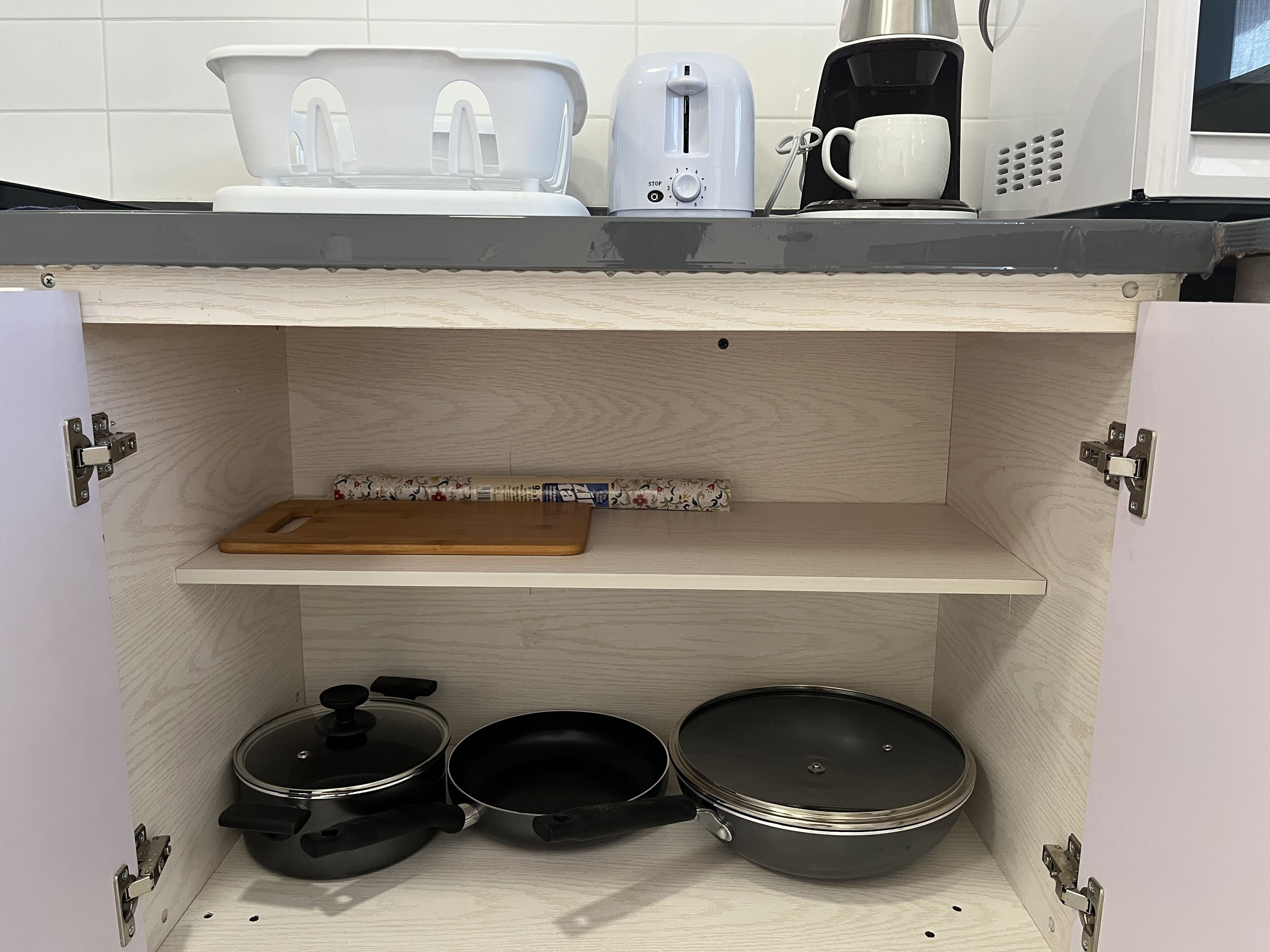 Cozinha com bancada de madeira, torradeira, cafeteira e micro-ondas.