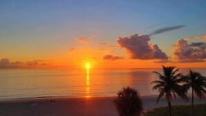 A sunset over a beach with palm trees and a clear sky. - Beautiful and Private Oceanfront Condo (Hollywood)