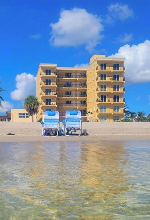 Na praia, espreguiçadeiras, toalhas de praia 