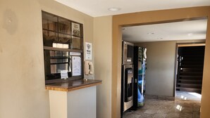 A hotel lobby with a reception desk, a phone, and a refrigerator. - Executive Inn (Oklahoma City)