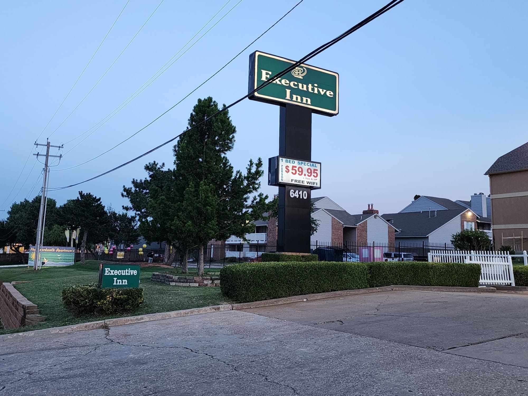 A sign for Executive Inn with a price tag of $59.95 per person, including tax and utilities, and a 6410 room number.