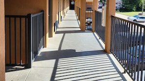 A corridor with a sign indicating an exit, flanked by railings and leading to a parking area. - Executive Inn (Oklahoma City)