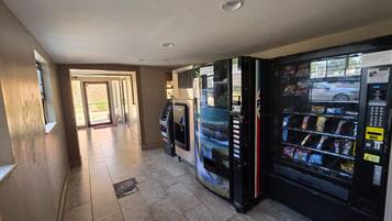 Un couloir avec des distributeurs automatiques et une porte donnant sur l’extérieur.
