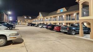 A motel with multiple parking spaces and a row of rooms with balconies. - Executive Inn (Oklahoma City)