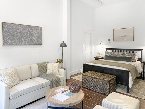 A modern bedroom with a bed, bedside tables, a sofa, and a coffee table. - Perch - Baker's Acres: Tranquil Studio on View Property (Langley)