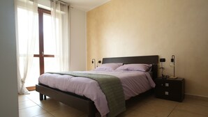 A bedroom with a bed, nightstands, and a window with curtains. - Bellavista Holiday Home (Abruzzo)