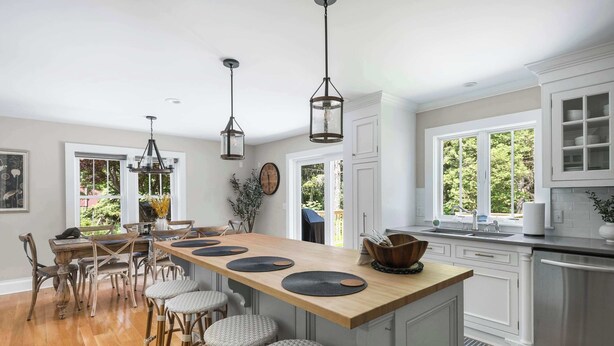 A spacious kitchen with a central island, wooden chairs, and pendant lighting. - Pet Friendly-Fenced Yard-Near Downtown (Skaneateles)