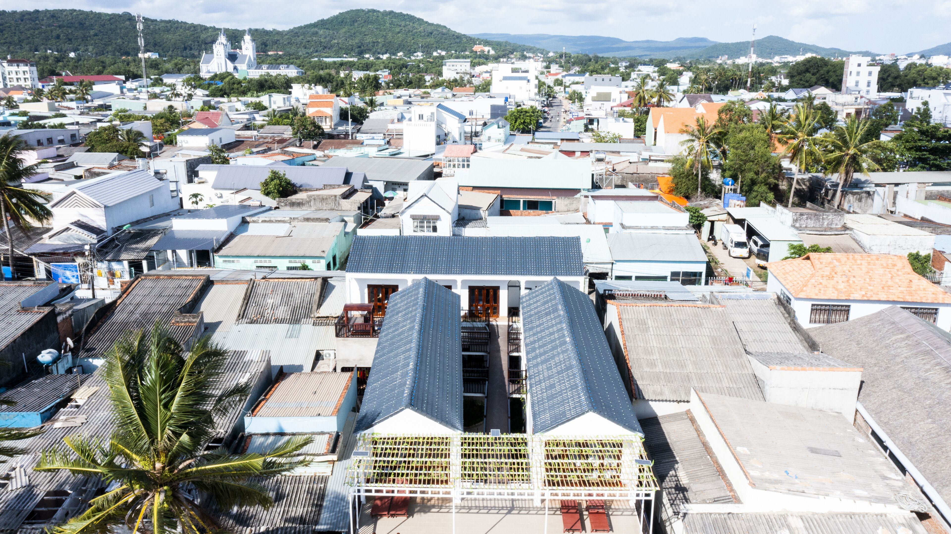 Une ville côtière qui se distingue par son église imposante, ses différents bâtiments et ses palmiers.