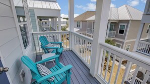 A balcony with teal Adirondack chairs and a view of neighboring houses. - Private Heated Pool | FREE Golf Cart | 5 BR Home | 5 Outdoor Spaces | Near Dune Allen Beach (Santa Rosa Beach)