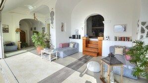 Amplia sala de estar con chimenea, asientos y una estantería.