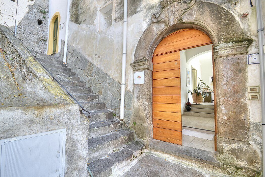 A stone staircase leading to a wooden door with a sign indicating room number 6.