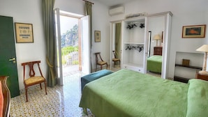 Une chambre avec deux lits, une armoire, une chaise et une petite table.
