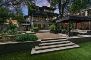 A modern house with a patio, outdoor seating, and a well-maintained garden. - Downtown Oasis : Heated Pool : Spa : Game room Sunday Ticket (Austin)