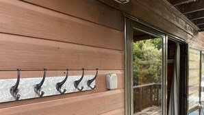 Eine Holzaußenwand mit einem Metallhakenleiste und einer Schiebetür aus Glas.