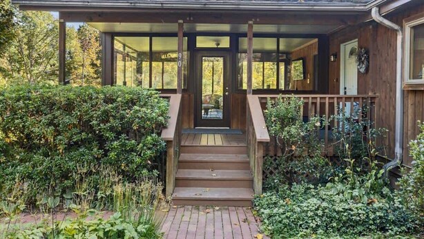 A wooden house with a covered porch and a brick pathway leading to the entrance. - Bright 2BR House w/ Sunroom + Fire Pit~Near Trails~Free Tickets (Hendersonville)