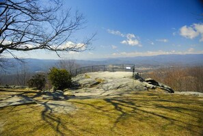 Un paysage rocheux avec une zone délimitée par une clôture et une vue dégagée sur les montagnes lointaines.