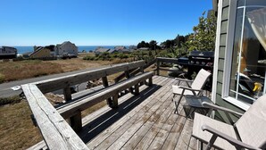 A wooden deck with a view of houses and the ocean.