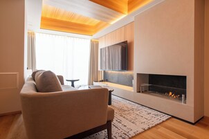 Una sala moderna con un sofá, un televisor de pantalla plana, una chimenea y un comedor.