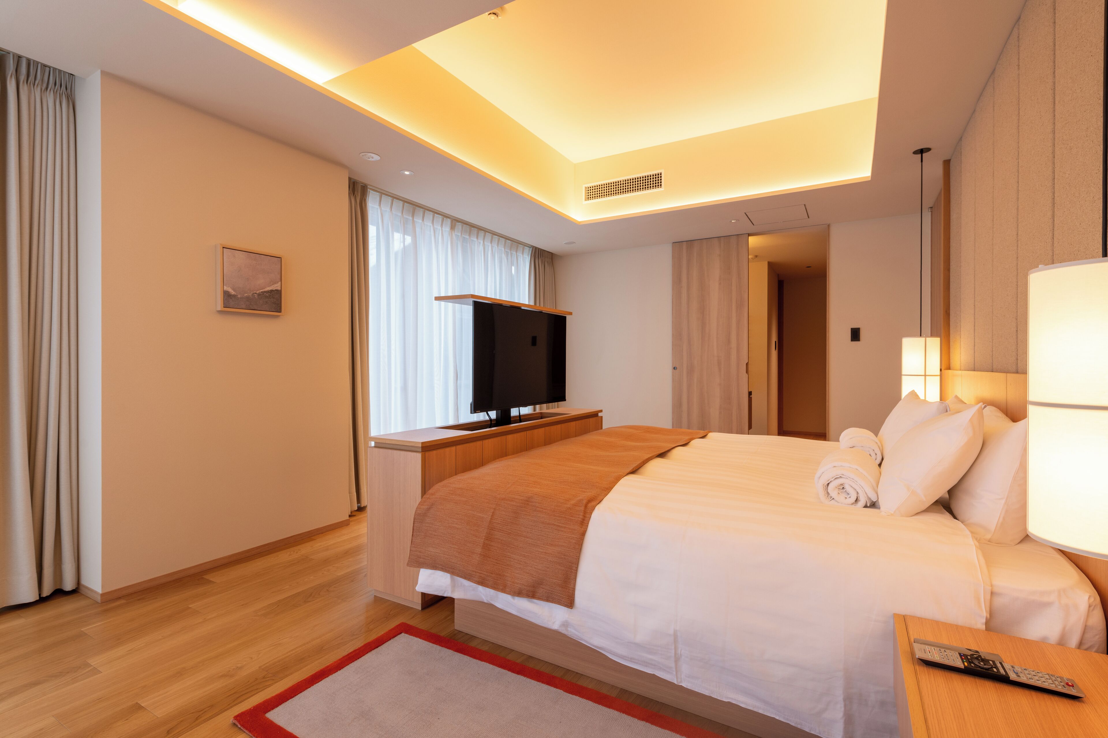 Une chambre d’hôtel avec un lit, une télévision, un bureau et une lampe.